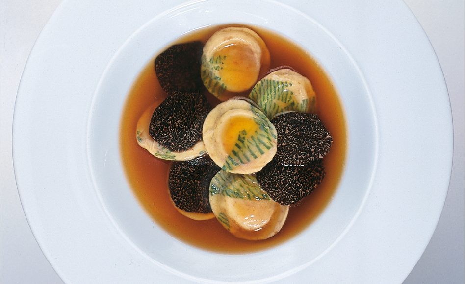 Consommé double aux petits ravioli imprimés à la moelle et râpée de truffe noire par Alain Ducasse