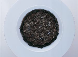 Des truffes noires en marmelade cassée, d’autres en fines lamelles, pommes de terre, fleur de sel