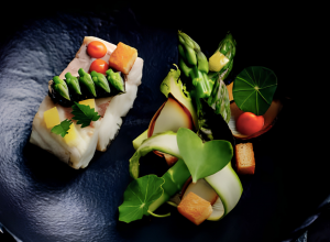 Loup de ligne confit au bois d’Inde, asperges aux piments végétariens et jus de blaff