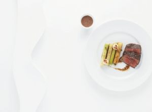 Faux-filet de bœuf Simmental frotté de poivre noir sur la braise, poireaux/pommes de terre et moelle par Alain Ducasse